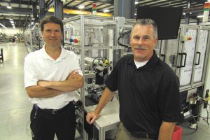 Invotec president and CEO standing next to equipment