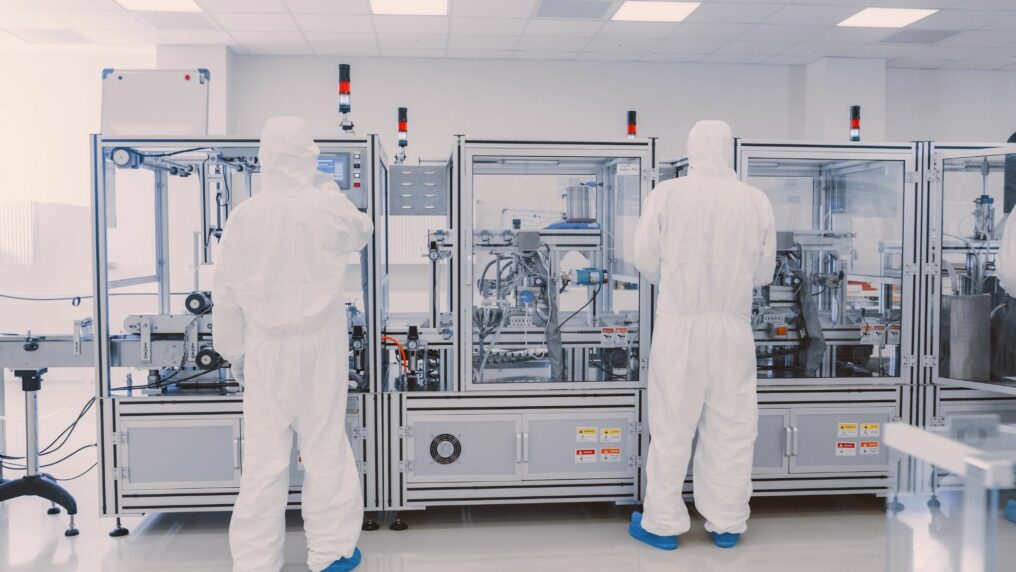 technicians work on automation equipment in clean room